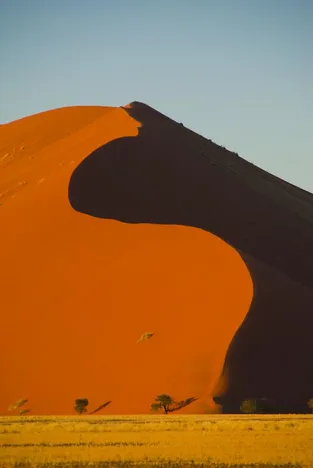 Bei Sonnenaufgang erstrahlen die Dünen in einem faszinierendem rot